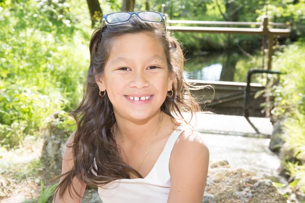 Bambino felice e sorridente ragazza con gli occhiali tra i capelli — Foto Stock