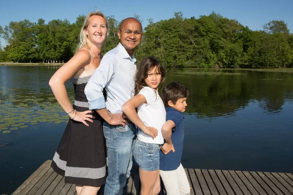 Mixed family of Indian origin in front of the park lake during the summer holidays — Stock Photo, Image