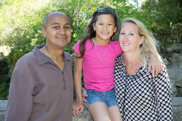 Mnohonárodnostní otec a matka s jejich mladé dívky v parku — Stock fotografie