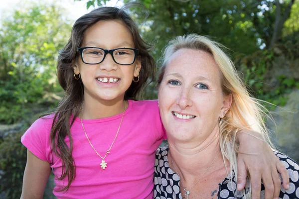 Rubia madre con sus gafas marrones hija en jardín parque — Foto de Stock