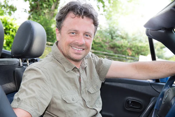 Middle-aged man sitting in her convertible car — Stock Photo, Image