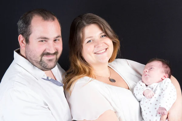 Smiling thirty-year-old couple with newborn baby — Stock Photo, Image