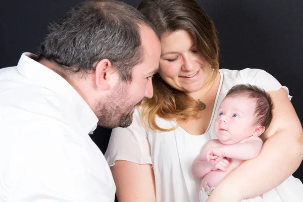 New born baby looks at his father in his mother arms — Stock Photo, Image