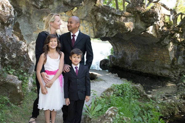 mixed family poses in front of the cave in reception clothes