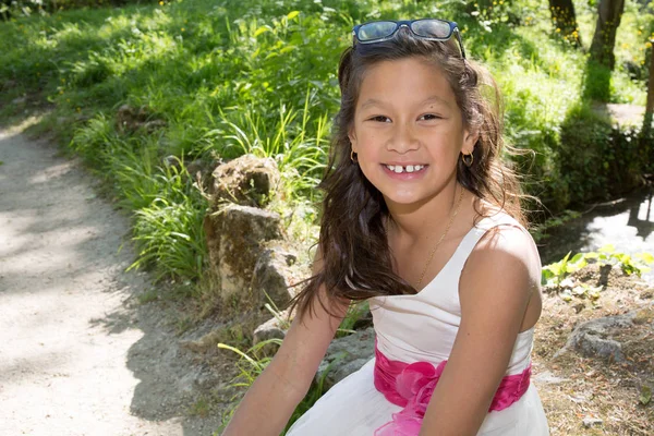 Giovane ragazza di 10 anni seduta in un parco — Foto Stock