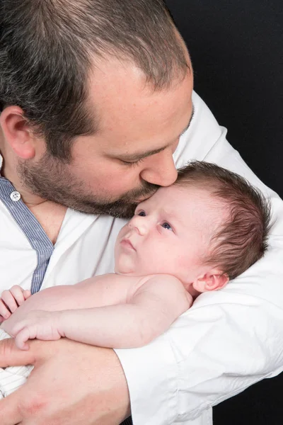 Newborn baby receives a kiss on his father — Stock Photo, Image