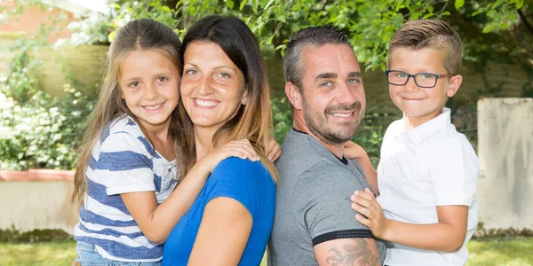 Dört bankta oturan mutlu aile portresi — Stok fotoğraf