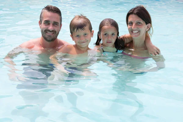 Niños niño y niña en la piscina de verano con los padres —  Fotos de Stock