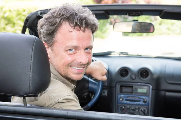 Smiling happy handsome man in car holidays — Stock Photo, Image