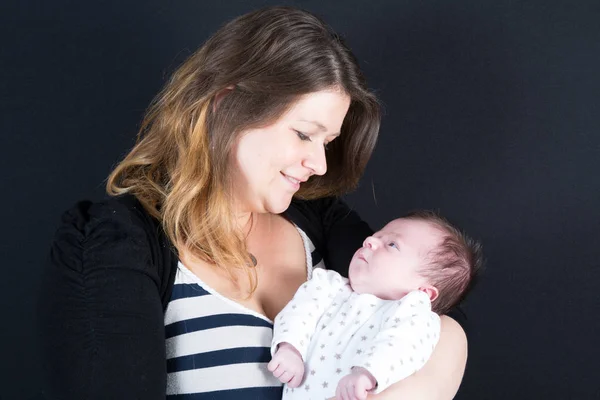 Joven madre lleva a su bebé recién nacido en sus brazos — Foto de Stock