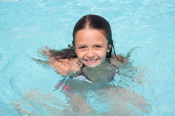 Happy little girl in the pool water during the summer holidays — Stock Photo, Image