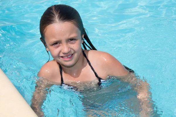 Encantadora niña en el agua de la piscina durante las vacaciones de verano —  Fotos de Stock