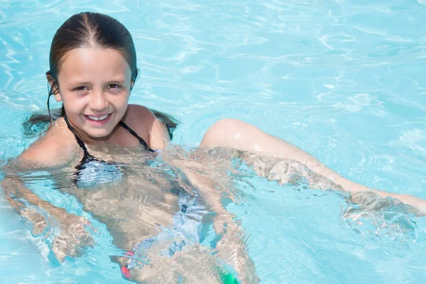 Hermosa niña se baña en la piscina del hotel —  Fotos de Stock