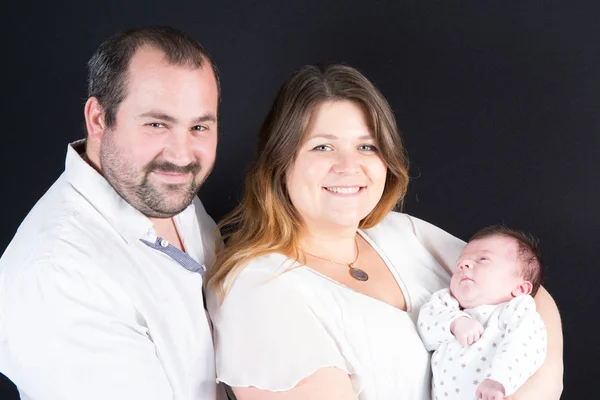 Vrolijke en gelukkige jonge familie met pasgeboren baby — Stockfoto