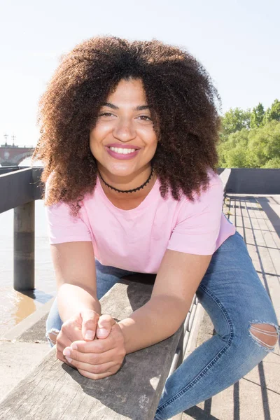 Beautiful young woman mixed curly in town on the docks — Stock Photo, Image