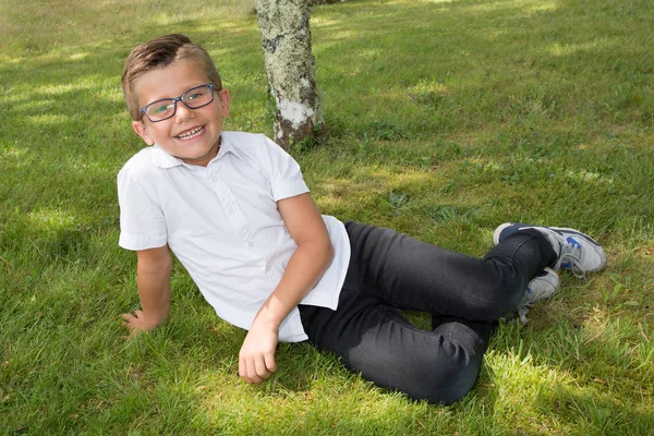 Liegen auf Gras Junge Kind lustig mit seiner Brille — Stockfoto