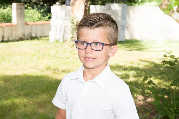 Joven chico rubio en el jardín familiar con gafas —  Fotos de Stock