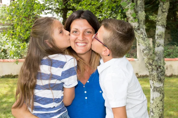 Gelukkige familie met kus van kind naar moeder — Stockfoto