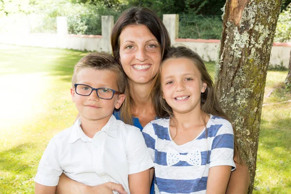 Zoon en dochter bij moeder in tuin Huis — Stockfoto