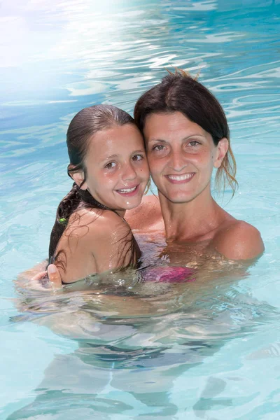 Feliz madre e hija en la piscina —  Fotos de Stock