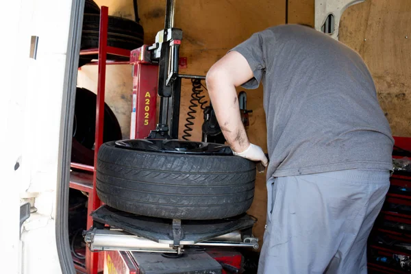 A gumi eltávolítása a kerék felni az autó a garázsban gép — Stock Fotó