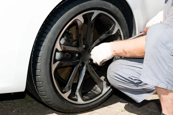 Técnico hombre viene a reparar una rueda perforada —  Fotos de Stock