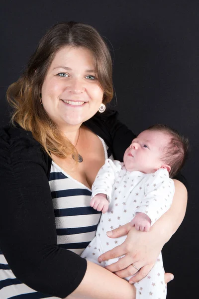 Neugeborenes Baby im Arm der Mutter vor schwarzem Hintergrund — Stockfoto