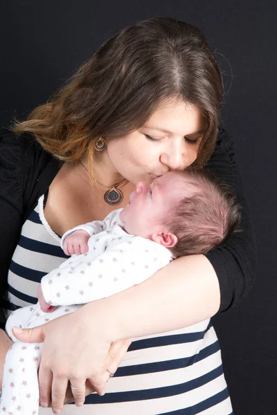 Moeder met een pasgeboren baby kussen met liefde — Stockfoto