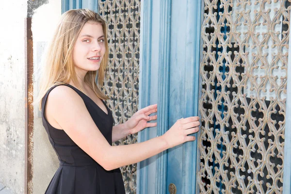Блондинка-подросток перед модой синих дверей — стоковое фото