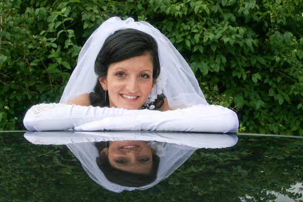 Schöne Braut auf dem Autodach — Stockfoto