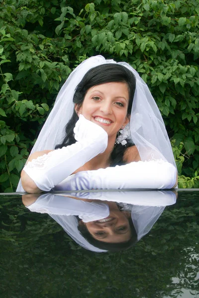 Reflectie van het gezicht van de mooie bruid op het dak van de auto — Stockfoto