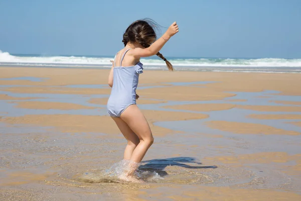 Bambina in vacanza estiva giocare e saltare in spiaggia di sabbia — Foto Stock