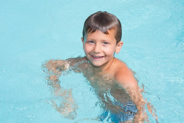 Smiling happy boy in summer pool — Stock Photo, Image