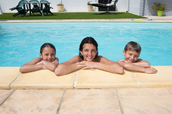 Madre hija e hijo placer en la piscina en casa en verano —  Fotos de Stock