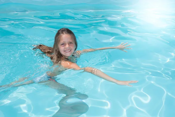 Little girl swimming in pool in summer vacation — Stock Photo, Image