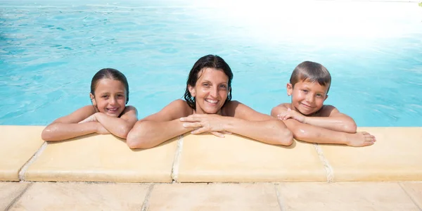 Familia feliz de 3 en la piscina en las vacaciones de verano —  Fotos de Stock