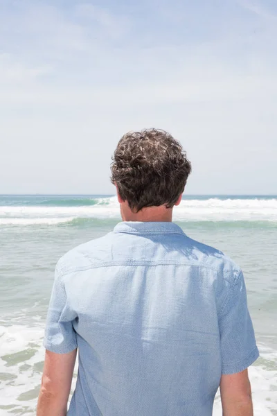 Een knappe man aan de zee oceaan — Stockfoto