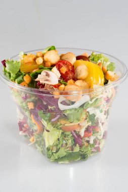 Beyaz arka plan üzerinde paket servisi olan restoran kapsayıcısında salata