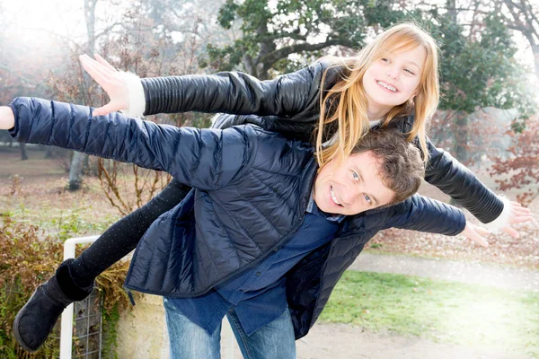 father Daddy and daughter playing. Adult and little girl blond piggyback outdoor autumn