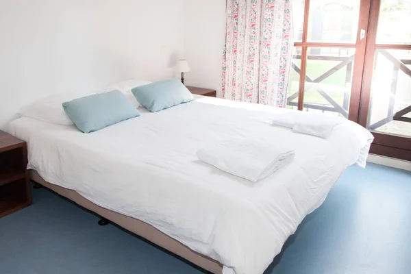Una cama grande muy hermosa en un dormitorio — Foto de Stock