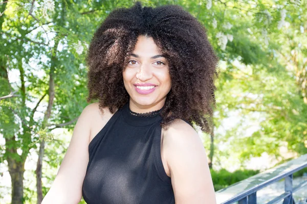 Sensual beautiful woman afro posing outdoor in black dress
