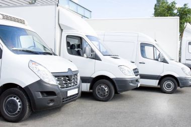 birkaç beyaz satır ticari teslimat vanlar ve hizmet van, kamyon ve araba fabrika depo dağıtım tesisi önünde