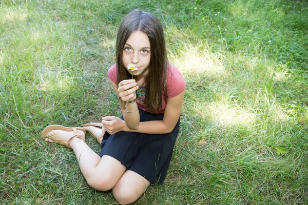 Aantrekkelijk Meisje Ontspannen Het Gras Met Bloemen Haar Handen Een — Stockfoto