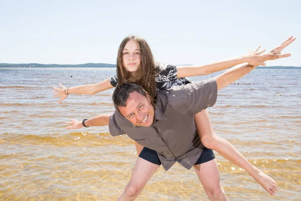 Portrait Father Giving Piggyback Ride Teenager Daughter Beach — Stock Photo, Image