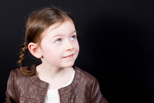 Cute little girl with bobbed hair cut looking away from camera