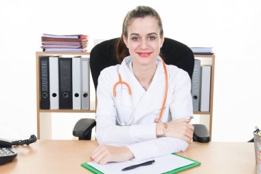 Sıradaki hasta için bekleyen onun masasında oturan güzel kadın doktor