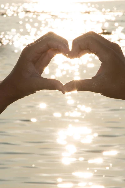 Kobiecych Rąk Postaci Serca Przed Woda Sea Zachód Słońca — Zdjęcie stockowe