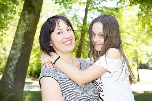 美しい母と笑みを浮かべて 公園でポーズをとる彼女のかなりの娘ティーンエイ ジャー — ストック写真