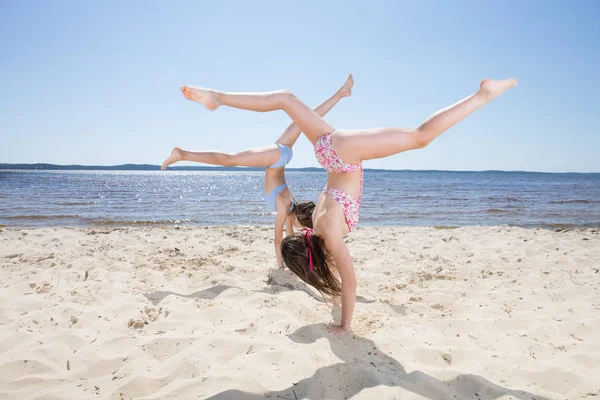 Dva Mladí Hezká Štíhlá Dívka Dělá Gymnastiku Pláži — Stock fotografie