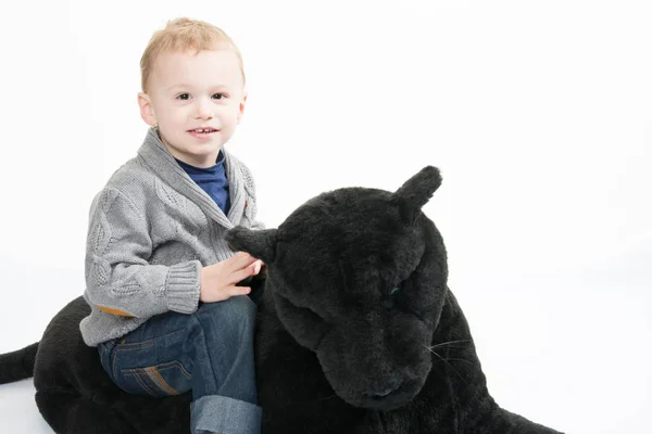 Jongen Zit Een Grote Zwarte Pluche Gelukkig Lachend Trots — Stockfoto